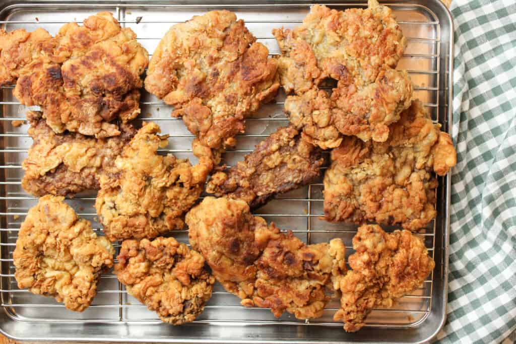 Overhead view of crispy chicken fried steak on a wire rack. 