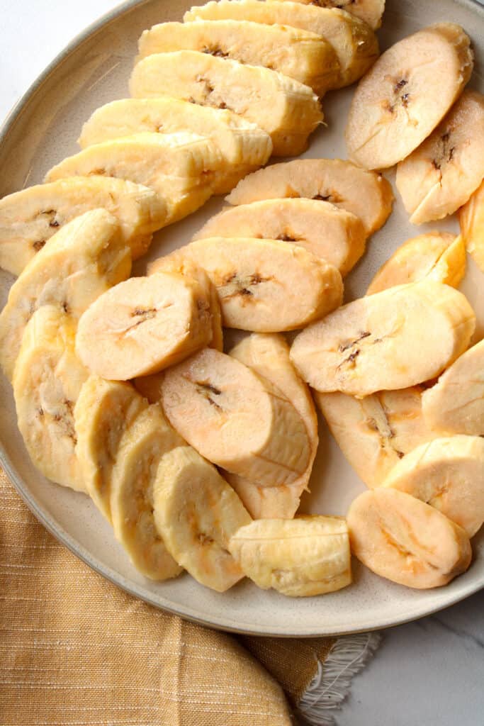 Sliced plantains on a plate, close up image.