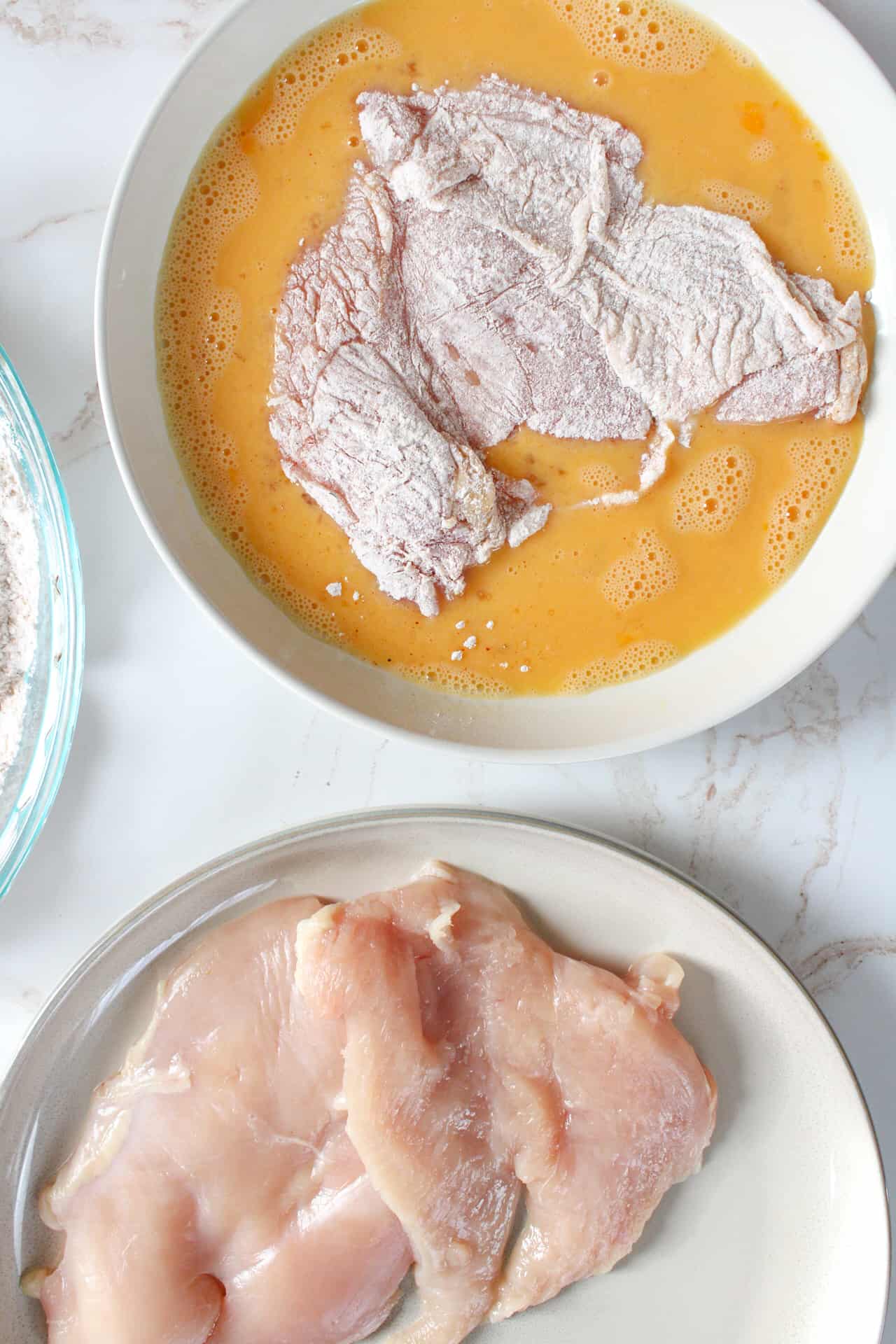 Floured chicken cutlet in the egg mixture.