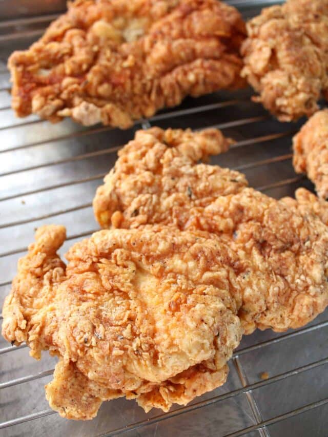 Crispy chicken fried chicken breast on a wire rack.