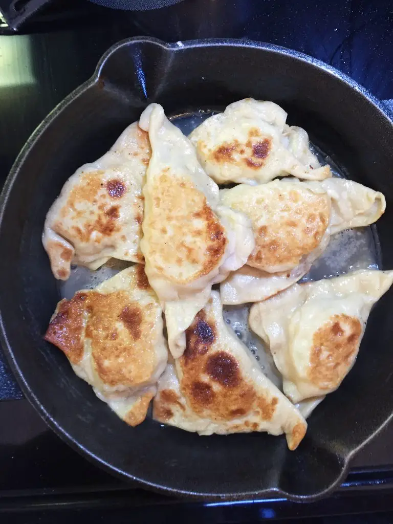Dumplings in a skillet as they cook.