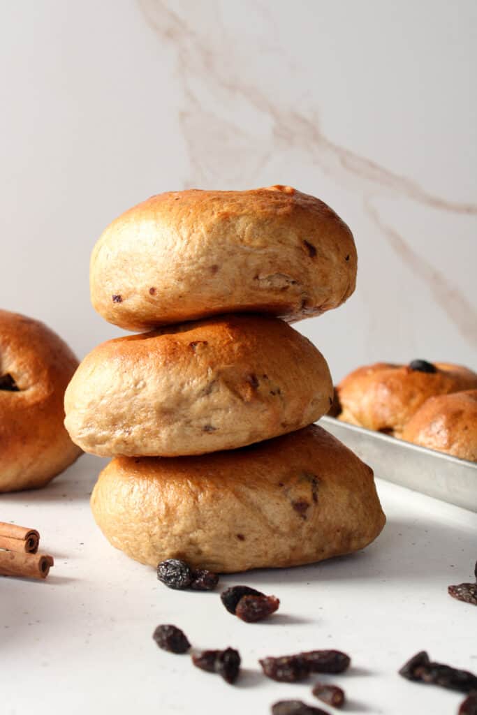 Stacked cinnamon raisin bagels on a table.