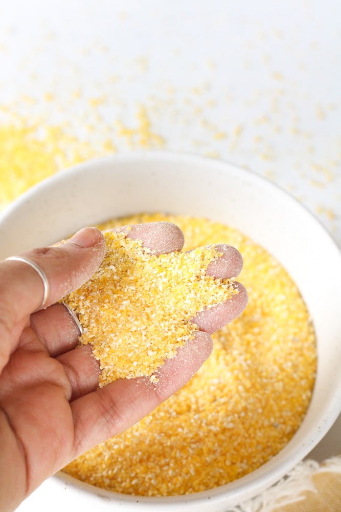 Woman's hand holding dry polenta.