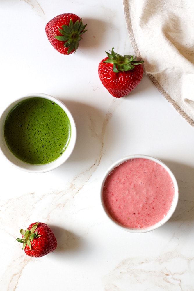 Overhead image of matcha mixture in a bowl with strawberry cream in another bowl.