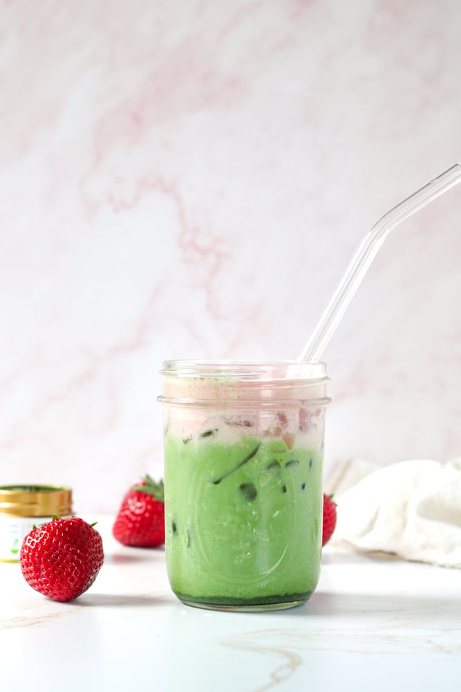 Side view of strawberry matcha latte in a mason jar.