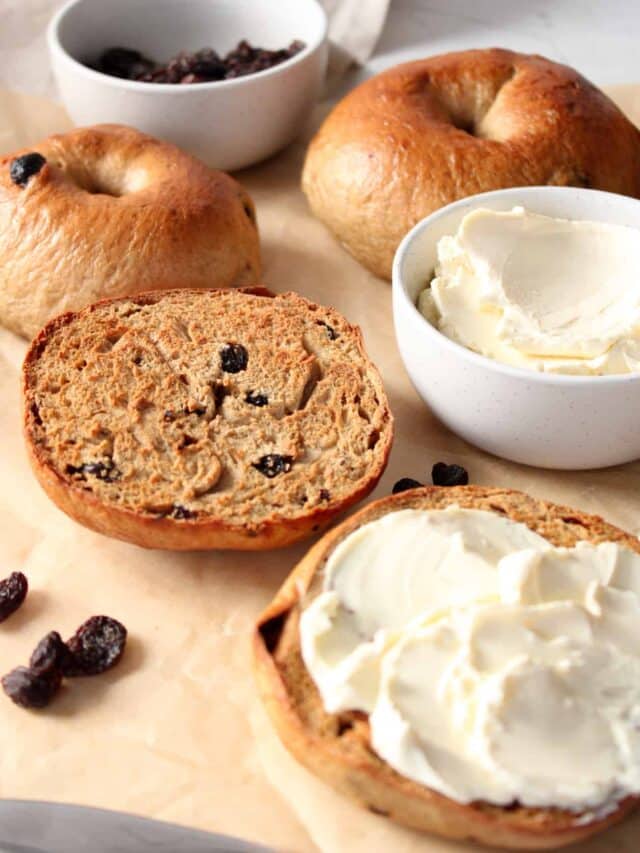 3/4 image of a cinnamon raisin bagel with cream cheese.