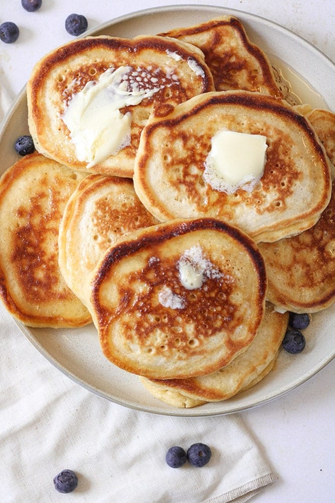 Close up on a stack of pancakes with butter and maple syrup. 