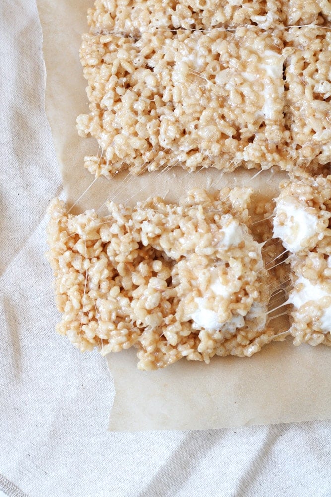 ¾ view of sliced rice krispie treats squares on parchment paper.