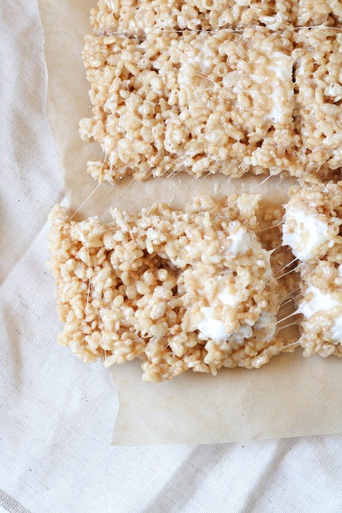 3/4 view of sliced rice krispie treats squares on parchment paper.