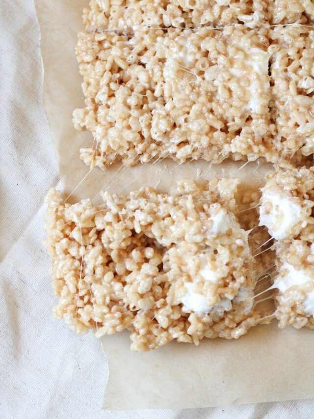 3/4 view of sliced rice krispie treats squares on parchment paper.