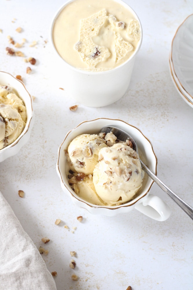 Close up image of ice cream in a tea cup with a spoon. 