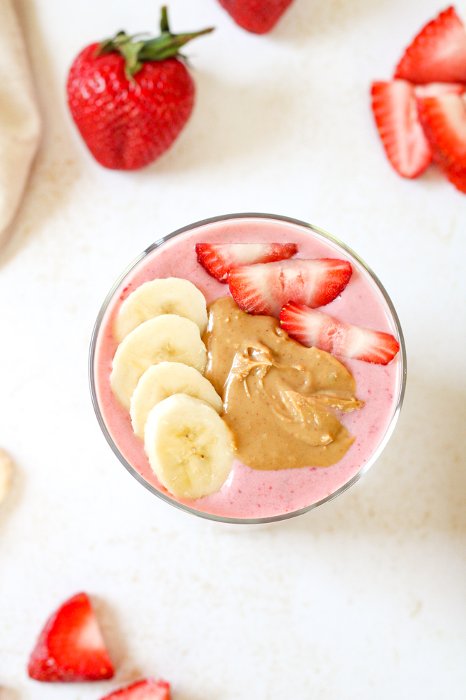 Overhead image of strawberry smoothie with toppings.