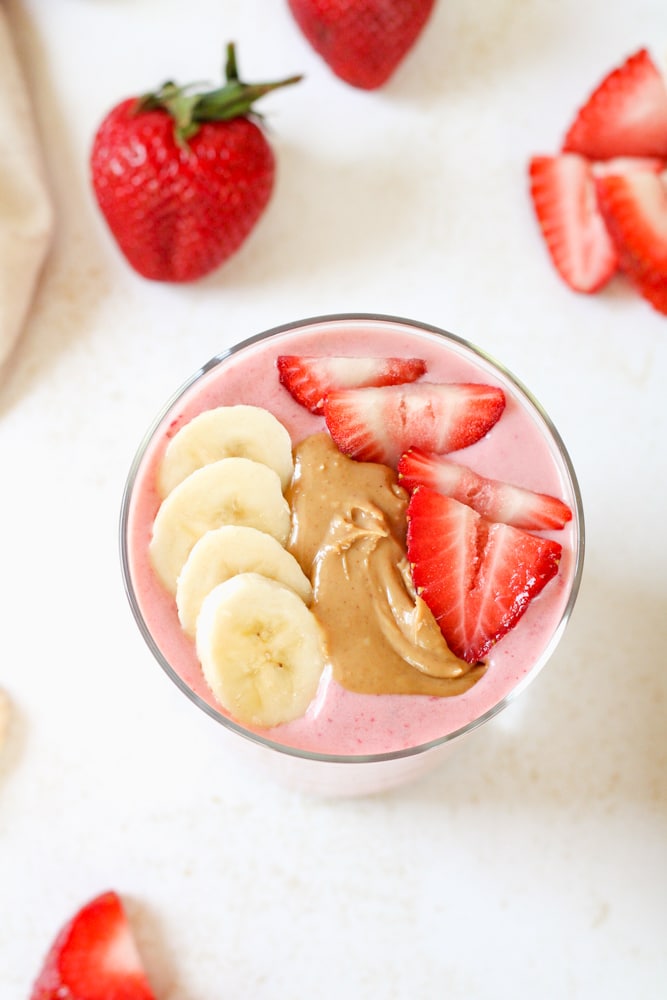 Overhead view of strawberry smoothie with toppings.