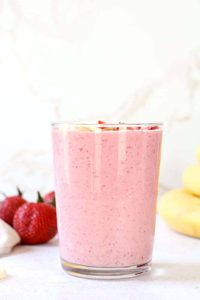 Side view of strawberry smoothie in a glass. 