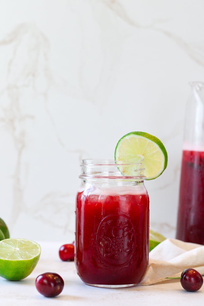 Limeade in a mason jar with a lime slice on the rim.