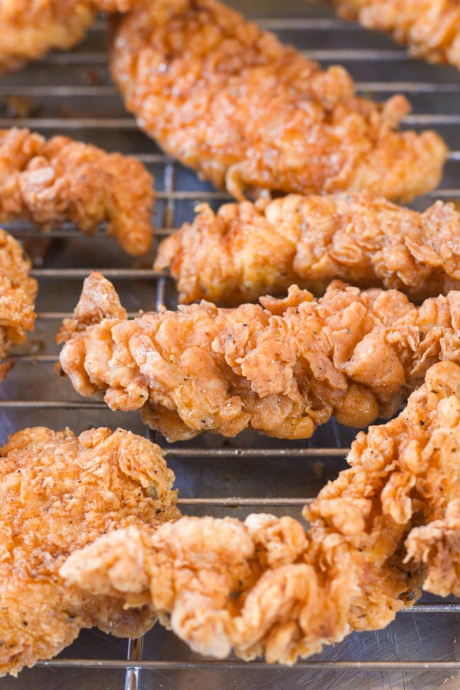 Close up image of crispy fried chicken on a wire rack.