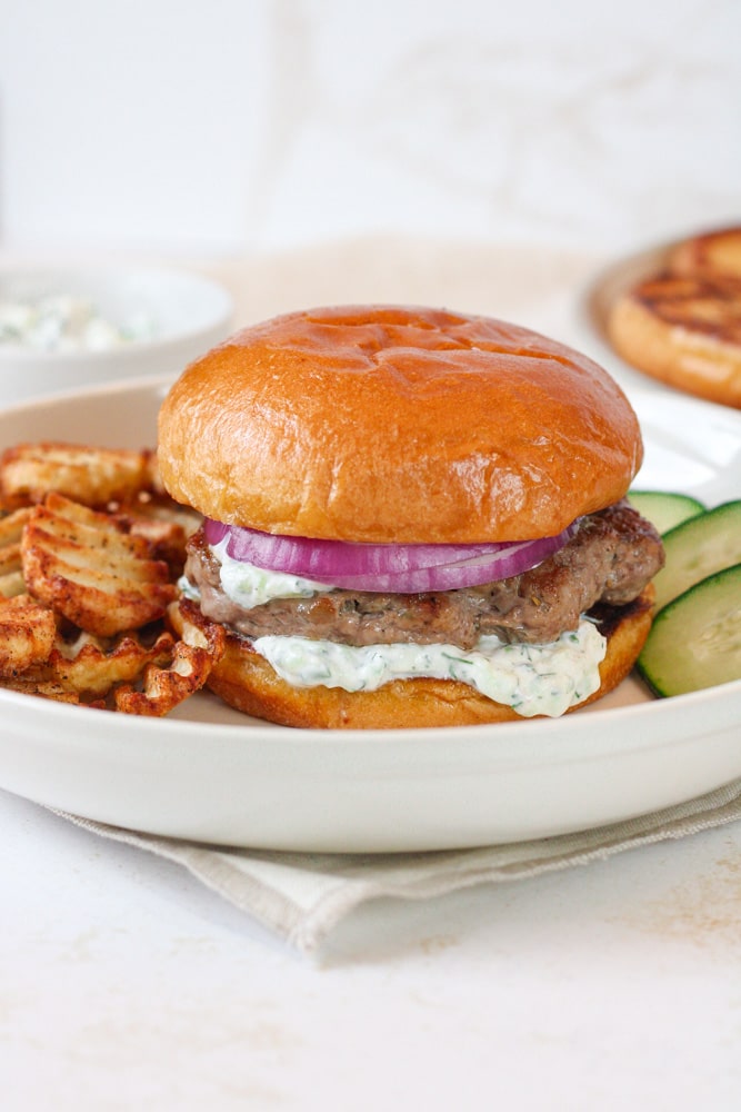 Side view of lamb burger patty on a plate.