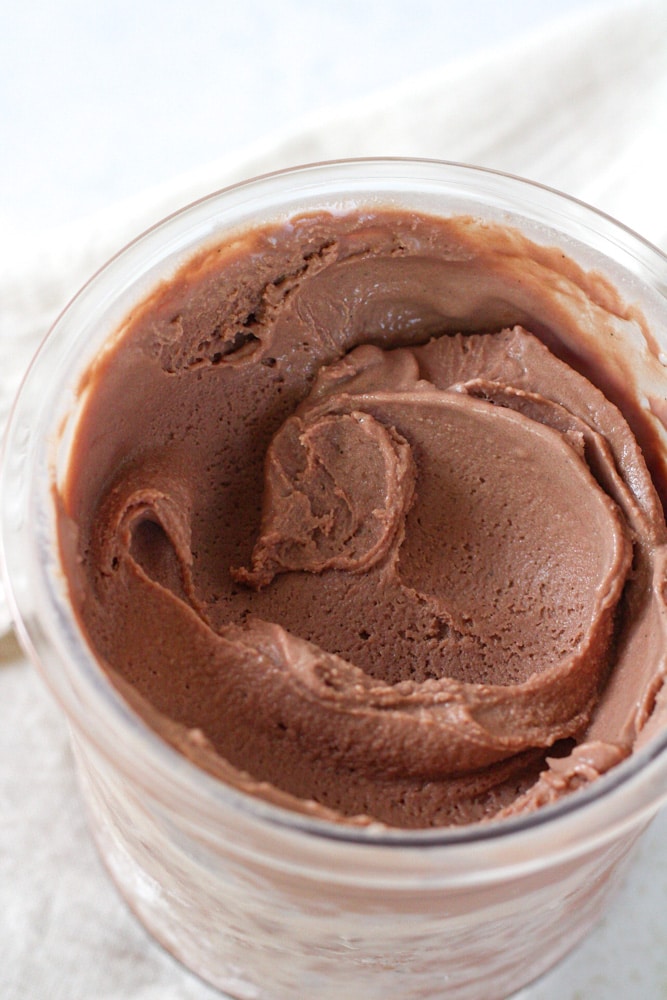 Close up on chocolate ice cream in the Ninja Creami pint container.