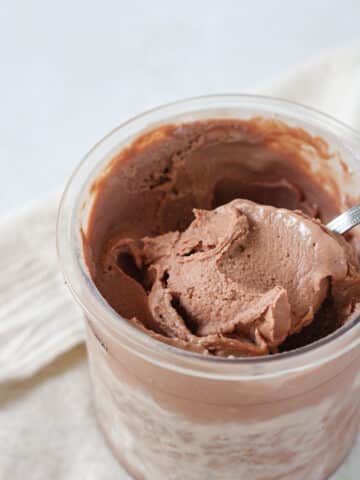 Close up on a scoop of chocolate ice cream in a pint container.