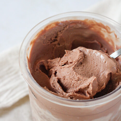 Close up on a scoop of chocolate ice cream in a pint container.