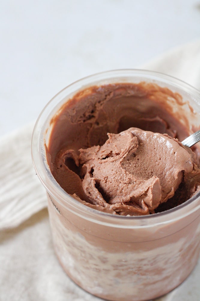 Close up on a scoop of chocolate ice cream in a pint container.