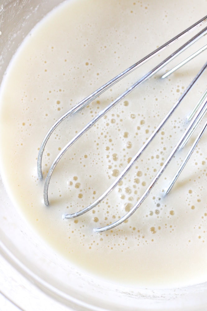 Ice cream base in a bowl with a whisk.