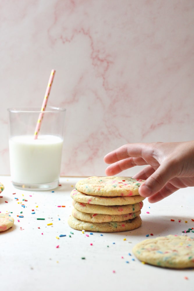 Child's hand reaching for a sugar cookie.