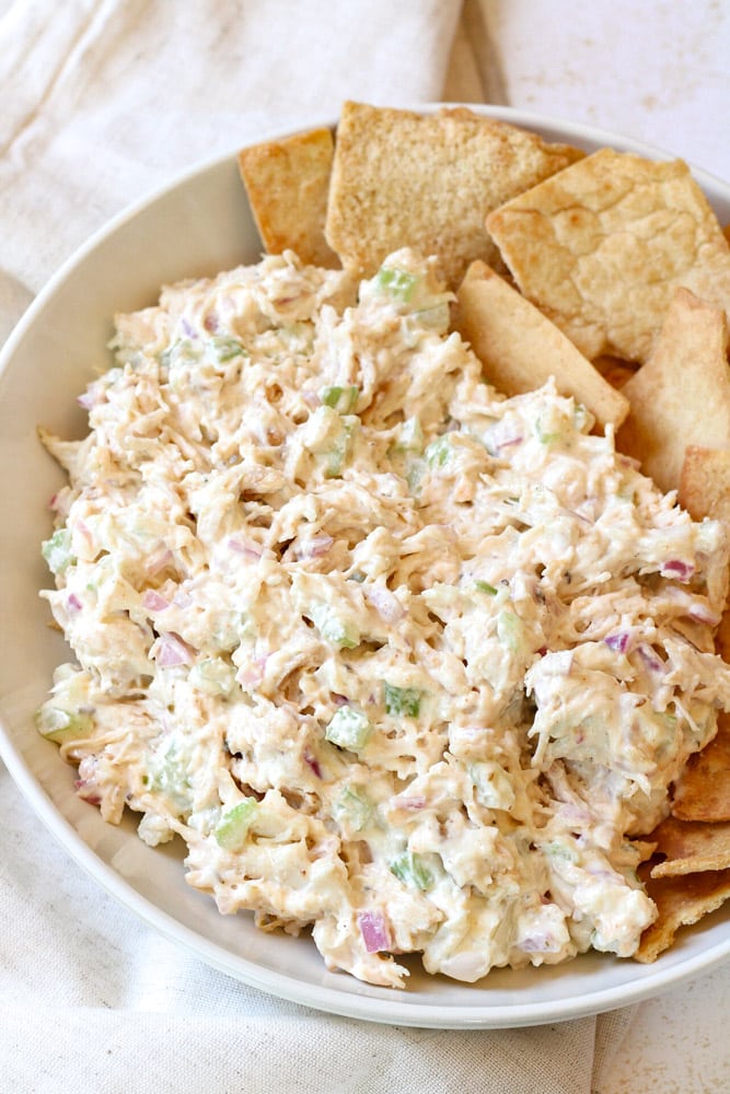 Close up image of chicken salad in a bowl with pita crackers.