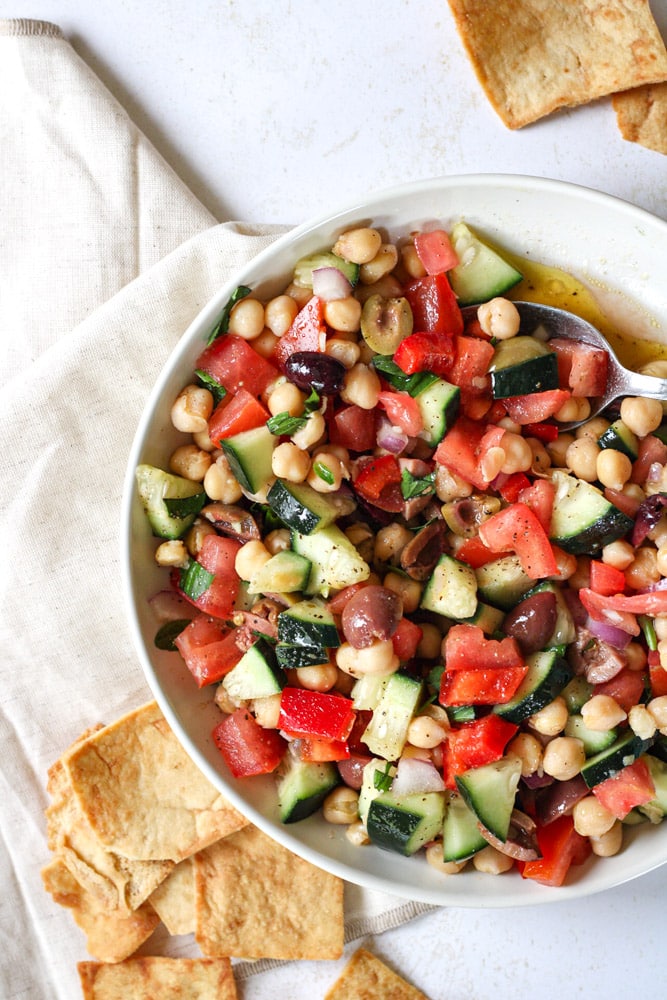 Bean salad in a bowl with a spoon.