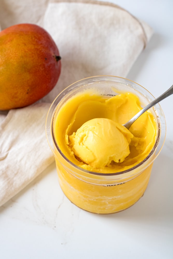A scoop of mango sorbet in a container.