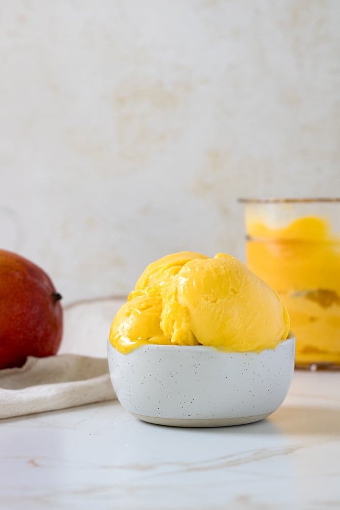 Side view of mango sorbet in a bowl.