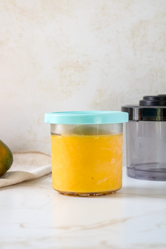 Frozen mango sorbet in a container.