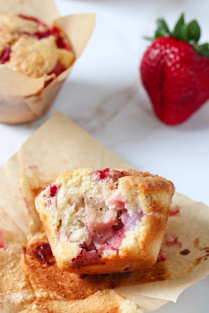 Broken strawberry muffin on a table.