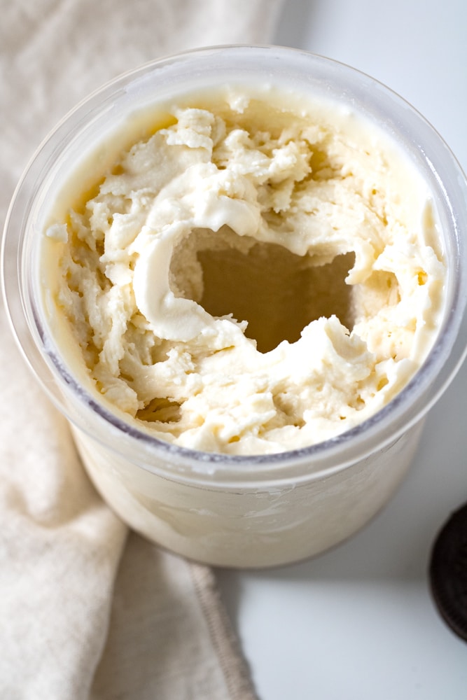 Vanilla ice cream in a pint container with a hole in the middle.
