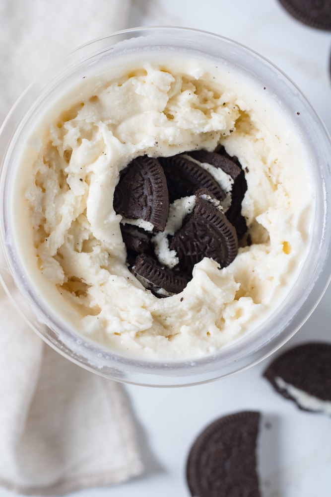 Vanilla ice cream with Oreo cookies in the middle of the container.