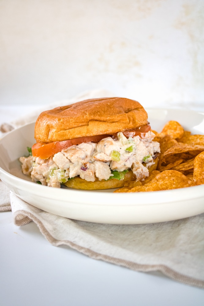 Chicken salad sandwich with lettuce and slices of tomato. 