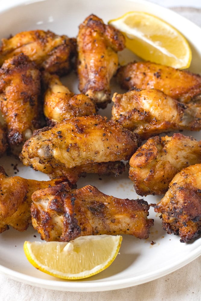 Crispy wings with lemon pepper on a plate.