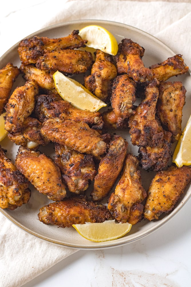 Air fryer lemon pepper wings on a plate.