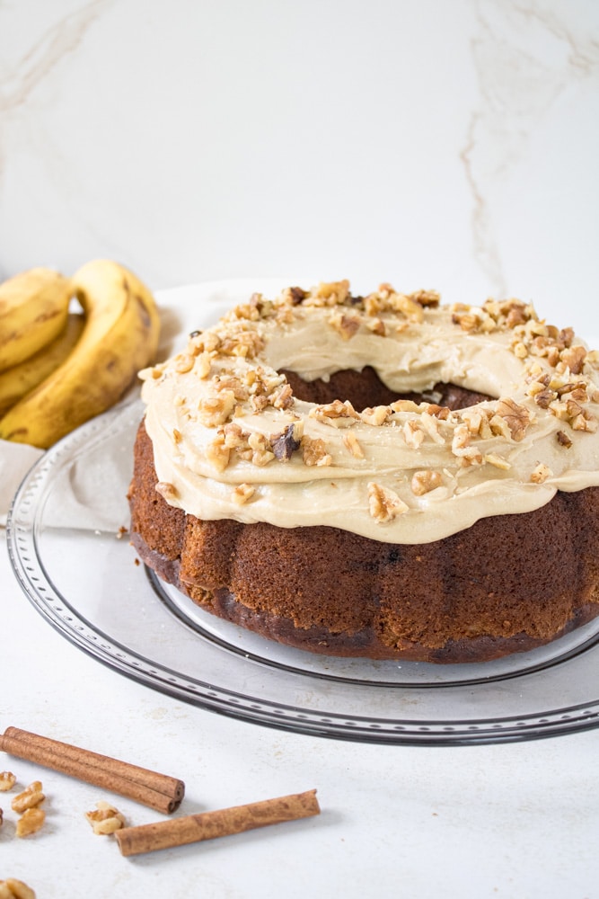 Side view of frosted banana cake with nuts.