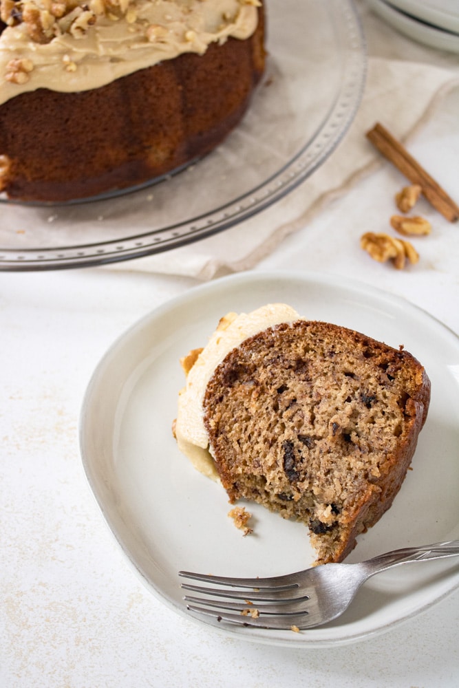 Slice of banana bread nut cake on a plate with a fork.