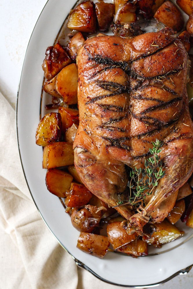 Whole roast duck on a serving platter.
