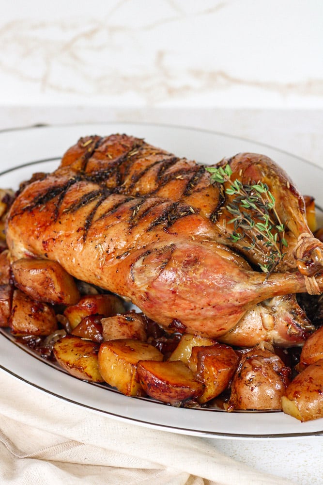 Side view of roast herb duck and potatoes.