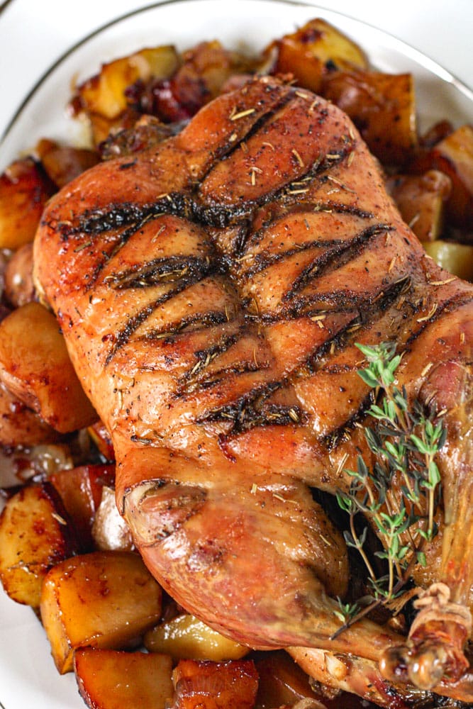 Close up image of roast whole duck with potatoes.