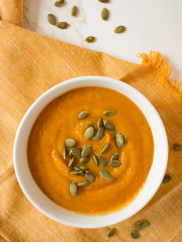 Roasted butternut squash soup in a bowl with pumpkin seeds.