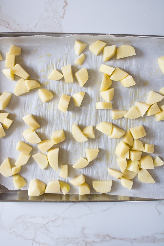 Cut potatoes on a baking sheet.