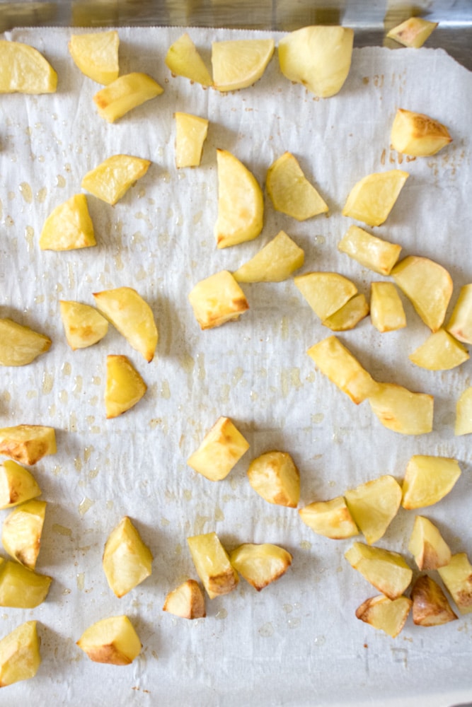 Baked potato cubes on a sheet pan.