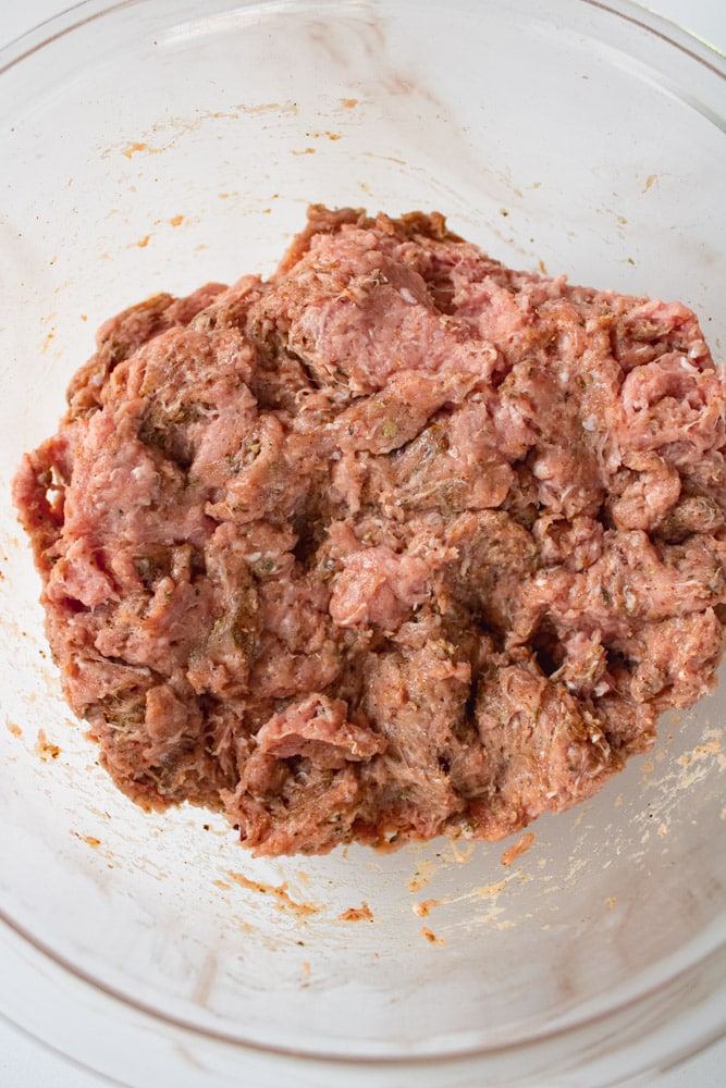 Mixed raw sausage meat in a bowl.