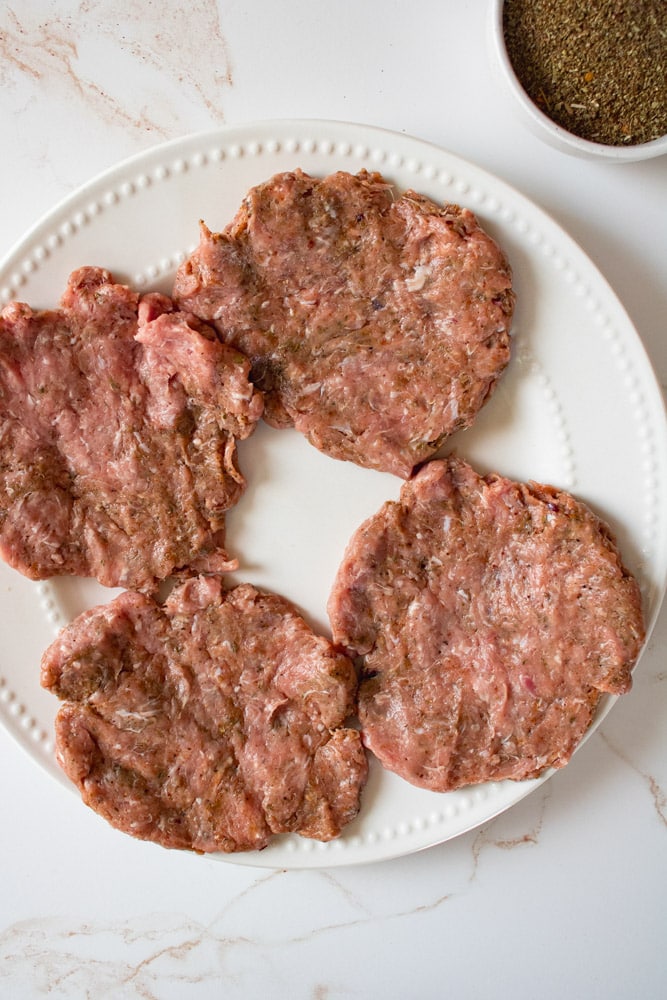 Flattened sausage patties on a plate.