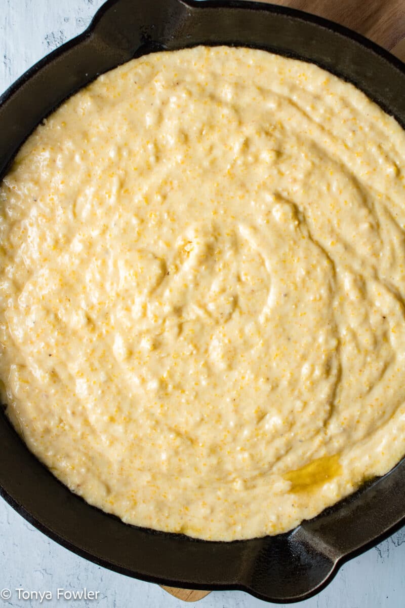 Cornbread batter in a cast iron skillet.