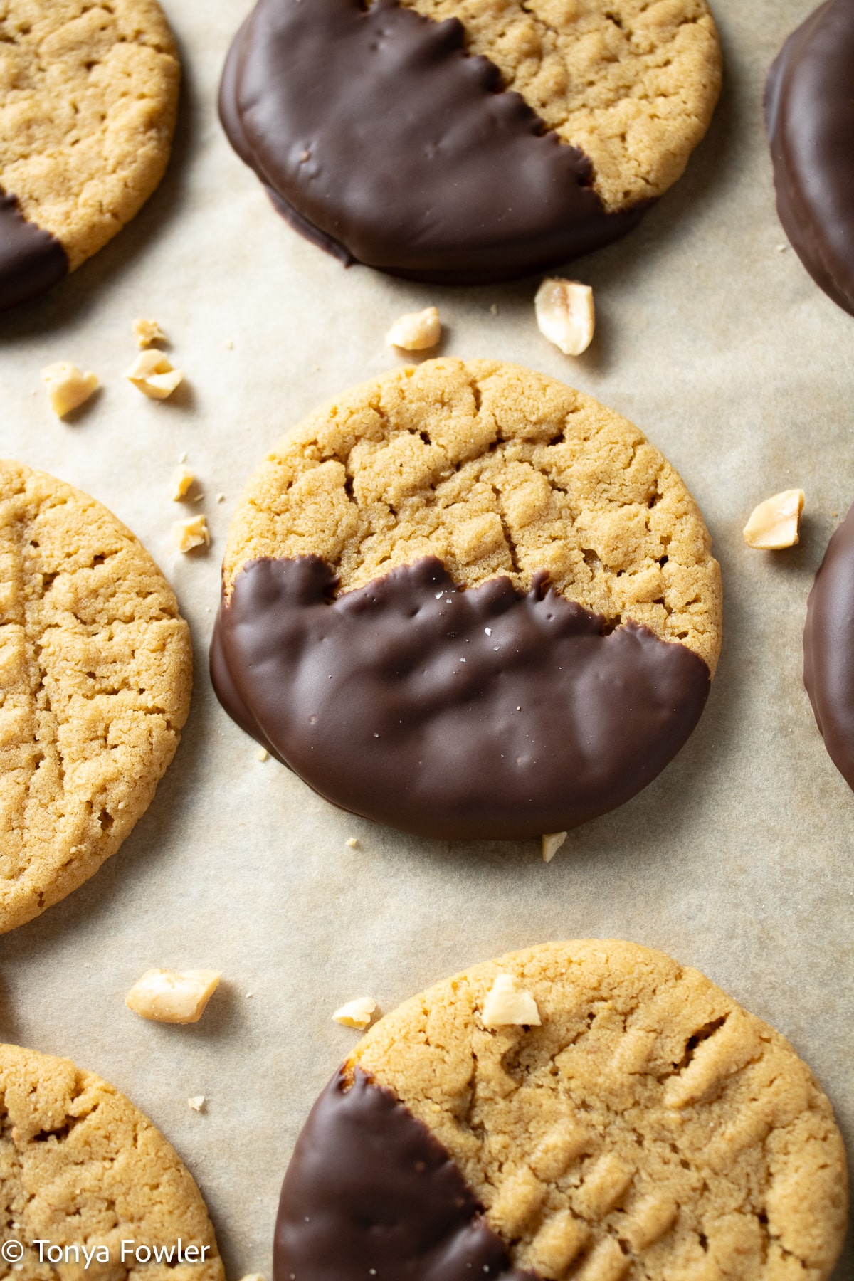 Chocolate dipped peanut butter cookies on a cookie sheet. 